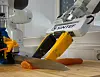 Tre robotarmer arbeider rundt en laksebit på et skjærebrett i et laboratorium.