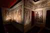 Museumsutstilling med opplyste veggmalerier.