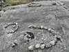 Tre mindre ringer laget av stein på en fjellknaus.