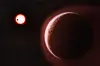 Kunstnerisk bilde av LHS 1140 b med en lys rand av atmosfære og en liten rød stjerne i bakgrunnen.
