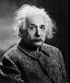 Svarthvitt portrett av Albert Einstein mot mørk bakgrunn.