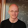 Profilbilde av Johannes Skaar foran en tavle med formler på.