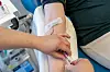 Helsearbeider tar blodprøve fra en pasients arm på sykehus.