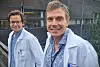 Asbjørn Christophersen og Andreas Lossius i hvite frakker poserer foran en moderne bygning.