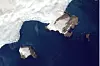 Satellittbilde av hvit iskant mot mørkeblått hav og små brune landområder. Du ser tydelig den nye øya.