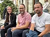 Tre voksne sitter utendørs foran en bygning, mens styrke- og balansetrening omtales som viktig for eldre.