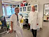 To personer i hvite laboratoriefrakker står i et medisinsk laboratorium.