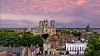 Luftfoto av York Minster og Yorks historiske sentrum under en rosa solnedgangshimmel.
