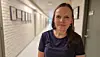 Heidi Sjursen Konestabo står i en lys korridor med bilder på veggen.
