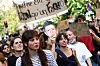 Kvinnelige demonstranter i Paris med plakater og en maske av Jean-Luc Mélenchon under en skoleprotest.
