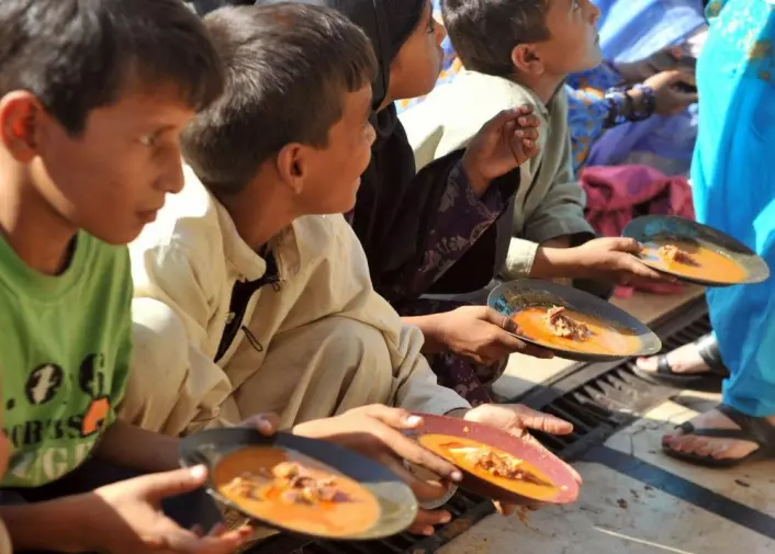 WHO anslår at under 9 prosent av verdens befolkning nå er undervektige. Disse barna får delt ut mat utenfor en restaurant i Karachi i Pakistan. Mer enn fire ganger så mange – nesten 40 prosent av verdens befolkning – er overvektige. Av disse har over 13 prosent fedme. (Foto: Rizwan Tabassum/AFP/NTB scanpix)