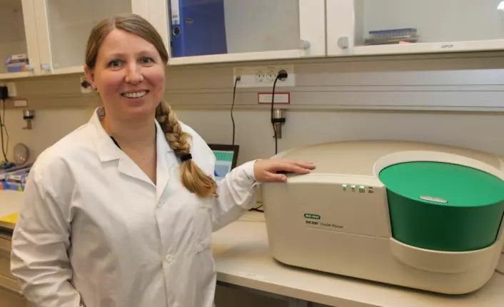 Professor Guro Lind med en digital PCR-maskin som blir brukt til å utvikle den nye urinprøve-baserte metoden for å påvise kreft i urinblæra. Maskinen er mye mer avansert enn det fotbad-liknende utseendet kan tyde på. (Foto: Bjarne Røsjø)