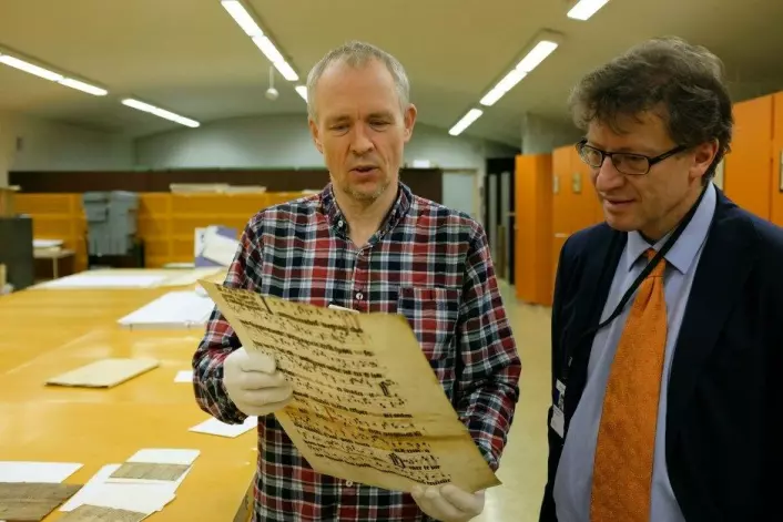 Tor Weidling (t.v.) og Espen Karlsen samarbeider om å finne gamle dokumentfragmenter. Dokumentet her er fra 1300-tallet. (Foto: Silja Björklund Einarsdóttir/forskning.no)