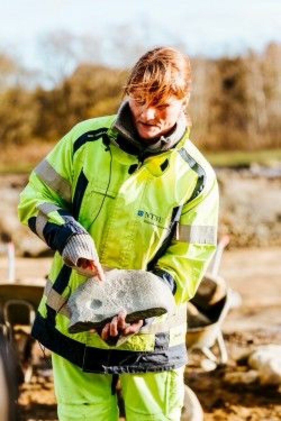 Prosjektleder Merete Moe Henriksen med hella som ble funnet på utgravningsområdet ved Sandbrauta i Lundamo i Melhus kommune. (Foto: Julie Gloppe Solem, NTNU)