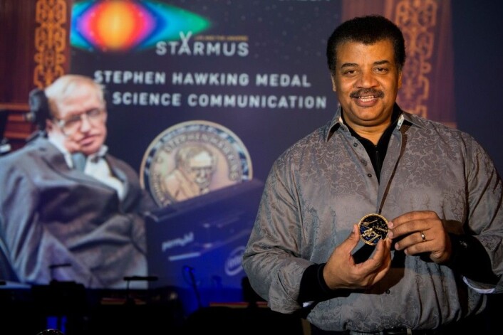 Neil deGrasse Tyson med Stephen Hawking-medaljen for forskningsformidling. I bakgrunnen på storskjerm: Stephen Hawking selv. (Foto: Max Alexander, Starmus) Neil deGrasse Tyson med Stephen Hawking-medaljen for forskningsformidling. I bakgrunnen på storskjerm: Stephen Hawking selv. (Foto: Max Alexander, Starmus)