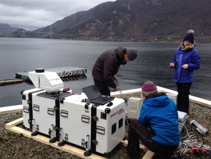 Her ser vi forskerne i aksjon sammen med laserinstrumentet, en langrekkevide-lidar med navn WindCube100S, plassert ved Lysefjordsenteret. Lysefjordbrua er i bakgrunnen. UiS-forskerne Jasna B. Jakobsen med ryggen til og Etienne Cheynet, begge fra UiS, og Valerie Kummer fra UiB. (Foto: Benny Svardal / CMR) Her ser vi forskerne i aksjon sammen med laserinstrumentet, en langrekkevide-lidar med navn WindCube100S, plassert ved Lysefjordsenteret. Lysefjordbrua er i bakgrunnen. UiS-forskerne Jasna B. Jakobsen med ryggen til og Etienne Cheynet, begge fra UiS, og Valerie Kummer fra UiB. (Foto: Benny Svardal / CMR)